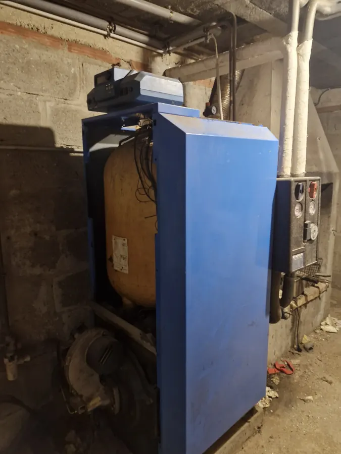 Chaudière bleue et conduit de fumée dans une chaufferie
