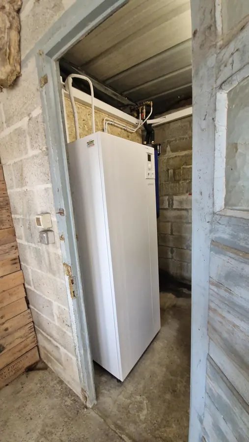 Module intérieur de chauffage blanc dans un local aux murs en parpaings