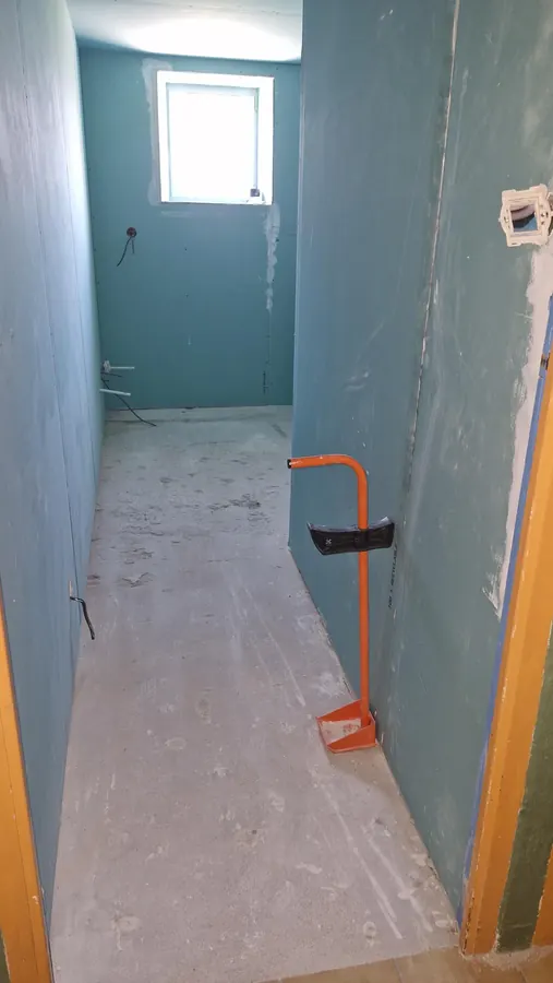 Salle de bains en chantier avec parois préparées et attentes de plomberie