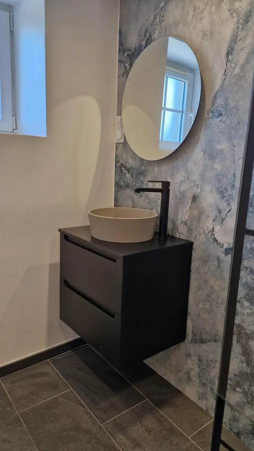 Vasque à poser, meuble suspendu, robinetterie et miroir rond éclairé